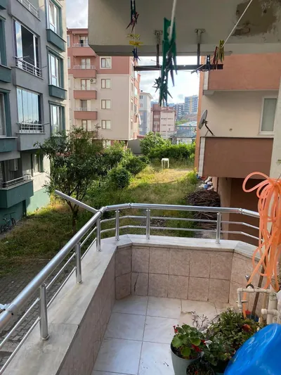 Zemin kat daire balkonunda doğal gri alüminyum korkuluk, çok köşeli duvar hattını dirseklerle dönüyor