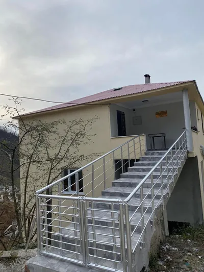 Krem sıvalı müstakil evin dış giriş merdiveninde çift taraflı alüminyum korkuluk ve kanatlı giriş kapısı