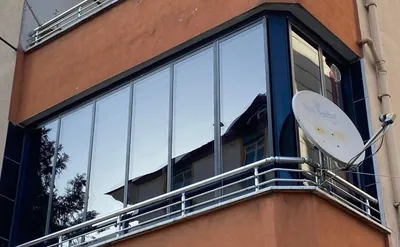 Sokak cephesinde dükkân üstündeki çıkma balkon gümüş alüminyum profilli sürme cam sistemle kapatılmış