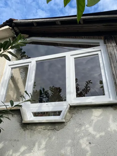 Beyaz PVC cumba pencere, eski taş evin cephesinde üçgen çıkmalı özel form olarak uygulanmış