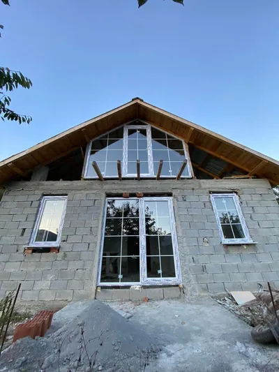 Üçgen çatı alınlığına özel üretilmiş PVC cam cephe ve altında karolajlı beyaz balkon kapısı